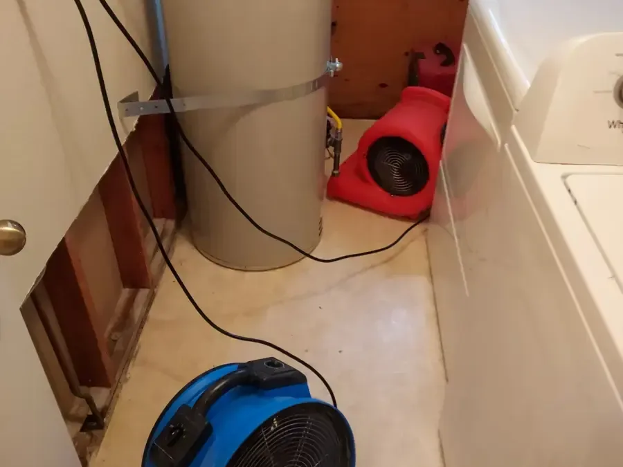 Blue and red air movers beside a water heater and washer