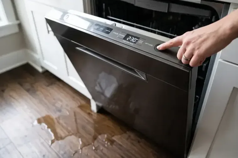 Dishwasher leak spreading across a hardwood kitchen floor